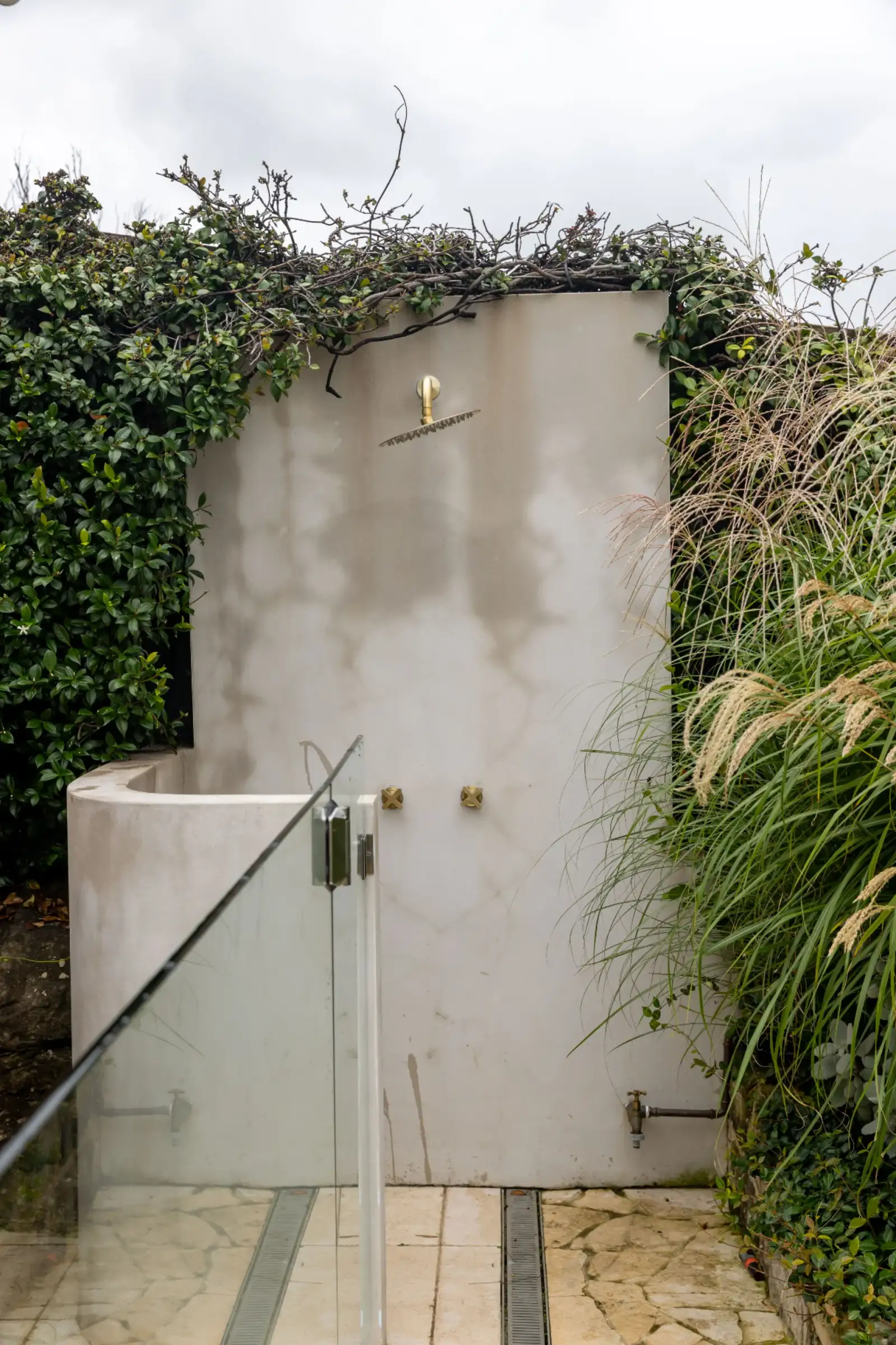 Bronte Pool - rendered outdoor shower with brass fixtures